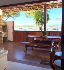 un patio con mesa y vistas al agua en Villa Palmeira, en Itacaré