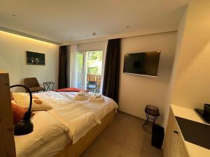 sypialnia z łóżkiem, telewizorem i oknem w obiekcie John's Lodge w mieście Les Collons