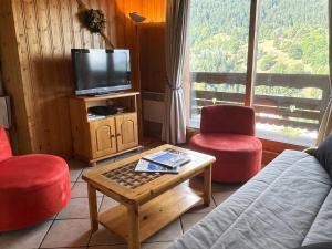 莱斯奥琉斯Appartement chaleureux avec balcon proche Méribel centre, 6 pers, 3 pièces - FR-1-411-225的客厅里有一张沙发、两把椅子和一台电视