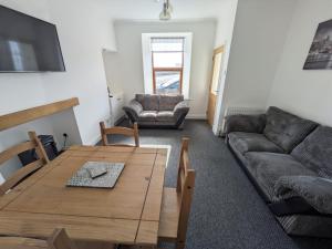 ウィックにある2 Bedroom Townhouse with Seaview on the NC500 Wickのソファとテーブルのあるリビングルーム
