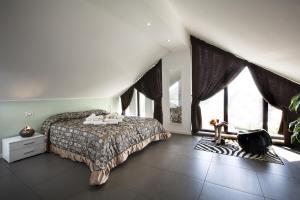 a bedroom with a bed and a large window at Villa Belohorizonte in Macerata
