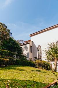 eine weiße Kirche mit einem Hof neben einem Gebäude in der Unterkunft Mosteiro Hotel de Charme próximo ao Vale dos Vinhedos in Garibaldi
