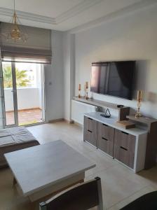 a living room with a large flat screen tv at Super appartement avec 5 piscines en résidence in Monastir