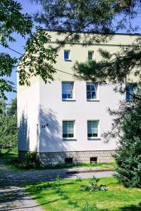 ein weißes Gebäude mit blauen Fenstern in der Unterkunft Apartament 5 minut od Parku Zamkowego in Pless