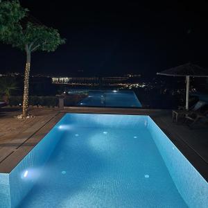 una piscina azul por la noche con vistas en Stergiou Luxury Apartments with shared pool, en Anavyssos