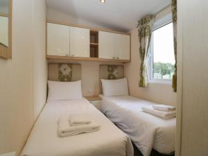 two beds in a small room with white sheets at Dove in Leominster