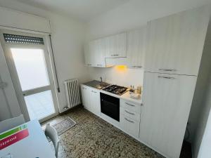 a kitchen with white cabinets and a stove top oven at SHUBY HOME in San Pietro Vernotico