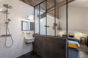 a bathroom with a sink and a shower and a bed at La Salamandre in Beauvais