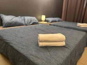 2 asciugamani posti sopra un letto di Vertex Studio Wi-Fi & Netflix a Cyberjaya