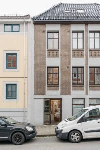 two cars parked in front of a building at Centrum Condo with Terrace in Bergen