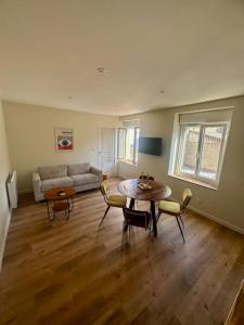 a living room with a table and a couch at Appartement au coeur de la Ville Fortifiée in Boulogne-sur-Mer