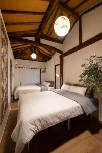 a bedroom with two beds in a room with wooden ceilings at MongYouHwaWon Guesthouse(Painter's house) in Jeonju