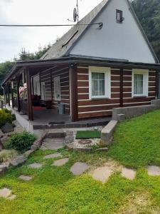 Chvaleč的住宿－Chalupa pod sjezdovkou，一座木屋,前面有一个院子