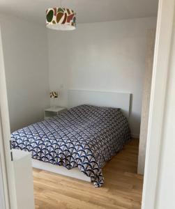 a bedroom with a bed in a white room at Very nice and quiet 42 m in Suresnes with parking in Suresnes