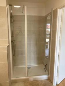 a shower with a glass door in a bathroom at Very nice and quiet 42 m in Suresnes with parking in Suresnes