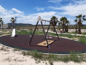 un parque de juegos vacío en la arena con palmeras en 3077 Residencia AZAHAR GARDEN, en Orihuela