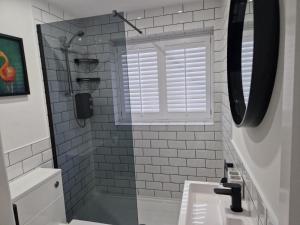 a bathroom with a sink and a shower with a window at Stylish 2 Bedroom Apartment Sleeps 4 Contractors and Corporates Welcome in Birmingham
