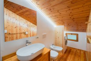 a bathroom with a white sink and a toilet at Ciasa de Sèn Jan in Pozza di Fassa