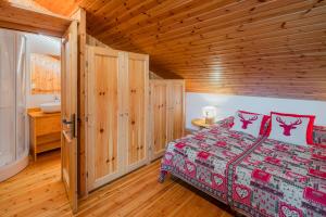a bedroom with a bed and a wooden ceiling at Ciasa de Sèn Jan in Pozza di Fassa