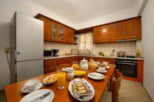 a kitchen with a wooden table with food on it at Xenia's Apartments in Alepou in Corfu