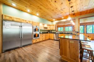 a kitchen with wooden cabinets and a stainless steel refrigerator at Large, Luxury, Views, Near Whiteface, Lake Placid in Wilmington