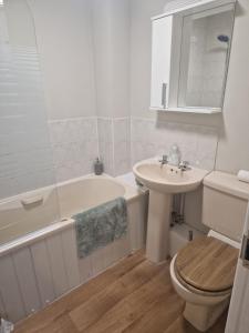 a bathroom with a tub and a toilet and a sink at The Bosville Arms in Rudston
