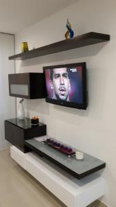 a television hanging on a wall with a shelf at Morros Epic Cartagena in Cartagena de Indias