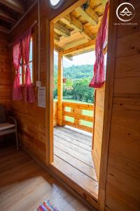 una puerta abierta a una cabaña de madera con ventana en Rafting Center "TARA-RAFT", en Bastasi