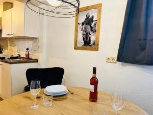 Una botella de vino sentada en una mesa de madera con copas en #Stadtspeicher - Blauer Stern das Apartment mitten in der Altstadt, en Rothenburg ob der Tauber