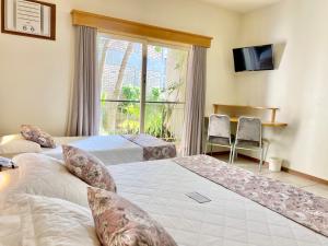 a hotel room with two beds and a window at Morada do Mar Hotel in Bombinhas