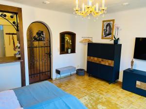 Un dormitorio con una cama azul y una lámpara de araña. en #Stadtspeicher - Blauer Stern das Apartment mitten in der Altstadt, en Rothenburg ob der Tauber