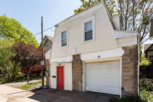 una casa bianca con una porta rossa e un garage di Comfortable home in Cornhill/DWTN/UofR/Strong Hosp a Rochester