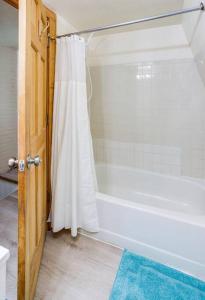 bagno con vasca bianca e tenda doccia di Comfortable home in Cornhill/DWTN/UofR/Strong Hosp a Rochester