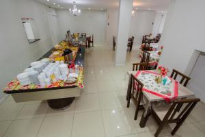 een restaurant met een tafel met borden en gerechten erop bij Pousada Augusta in Penha
