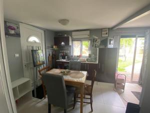 a kitchen with a table and a dining room at Cabane paisible à 15 min du futuroscope in Saint-Julien-lʼArs