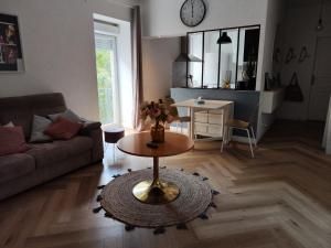 salon z kanapą i stołem w obiekcie LE PETIT ANGLE APPARTEMENT 2 Pièces, plein centre ville, près de la gare jusqu'à 4 personnes w mieście Bellegarde-sur-Valserine
