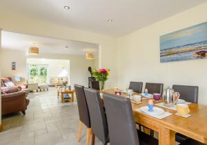 a dining room and living room with a table and chairs at Woodside in Thurgarton