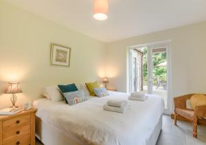 a bedroom with a large white bed and a window at Woodside in Thurgarton