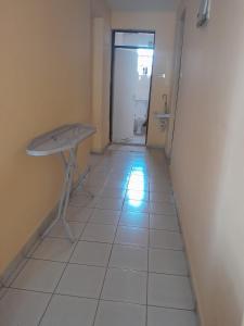 einen Flur mit einem Tisch und einem WC in einem Zimmer in der Unterkunft REHOBOTH'S APARTMENTS in Kisumu