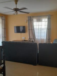 a living room with a couch and a ceiling fan at REHOBOTH'S APARTMENTS in Kisumu