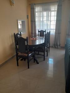 a dining room with a table and chairs and a window at REHOBOTH'S APARTMENTS in Kisumu