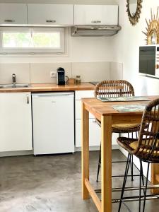 een keuken met een houten tafel en een witte koelkast bij Les Pinsons studio in La Ciotat