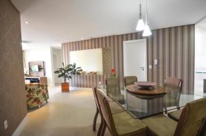 comedor con mesa de cristal y sillas en 1032 - Apartamento para locação no centro de Bombinhas - Residencial Boulervard - 210, en Bombinhas