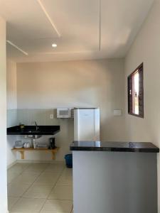 a kitchen with a counter top and a refrigerator at Gostoso Maresia Flats in São Miguel do Gostoso