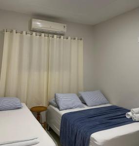 a bedroom with two beds and a air conditioner at Gostoso Maresia Flats in São Miguel do Gostoso