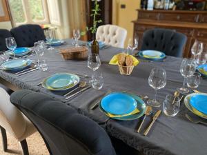 una mesa con platos azules y copas de vino. en Villa Monferrato, en Passerano 