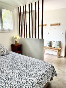 een slaapkamer met een bed en een raam en een bank bij Les Pinsons studio in La Ciotat +11 foto's