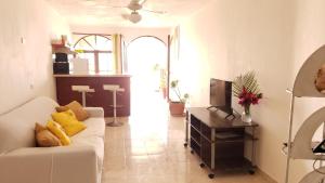 een woonkamer met een witte bank en een televisie bij Best ocean view 1 bedroom long term opportunity in Las Flores