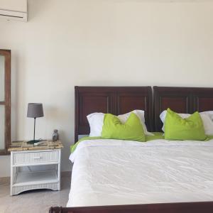 een slaapkamer met een groot bed met groene kussens bij Best ocean view 1 bedroom long term opportunity in Las Flores