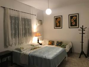 een slaapkamer met 2 aparte bedden en een lamp bij Happy Guest House in Navegantes